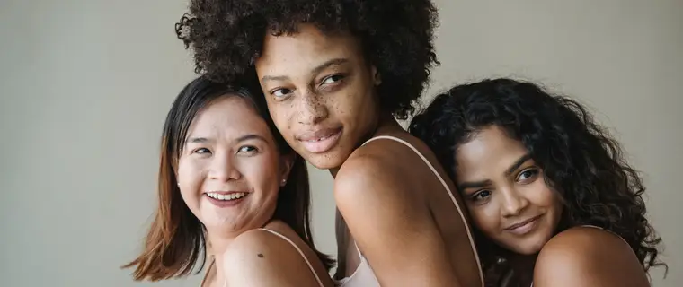 Three smiling clients representing the diversity of boutique beauty clientele