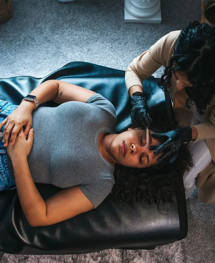 An overhead view of an eyebrow waxing treatment in progress