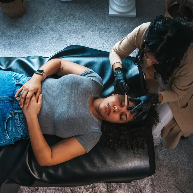 An overhead view of an eyebrow waxing treatment