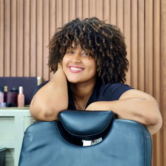 A smiling client with curly hair at a boutique salon
